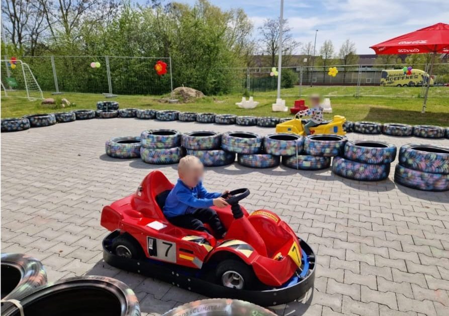Kinder fahren Elektro-GoKarts auf einer mit Reifen abgesteckten Bahn