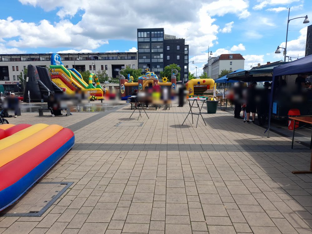 Mehrere Hüpfburgen und Spielgeräte nebeneinander auf einem Stadtfest