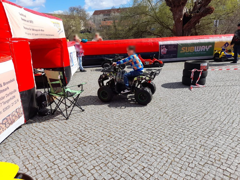 Kind fährt auf einem Elektro-Quad über einen abgesperrten Platz