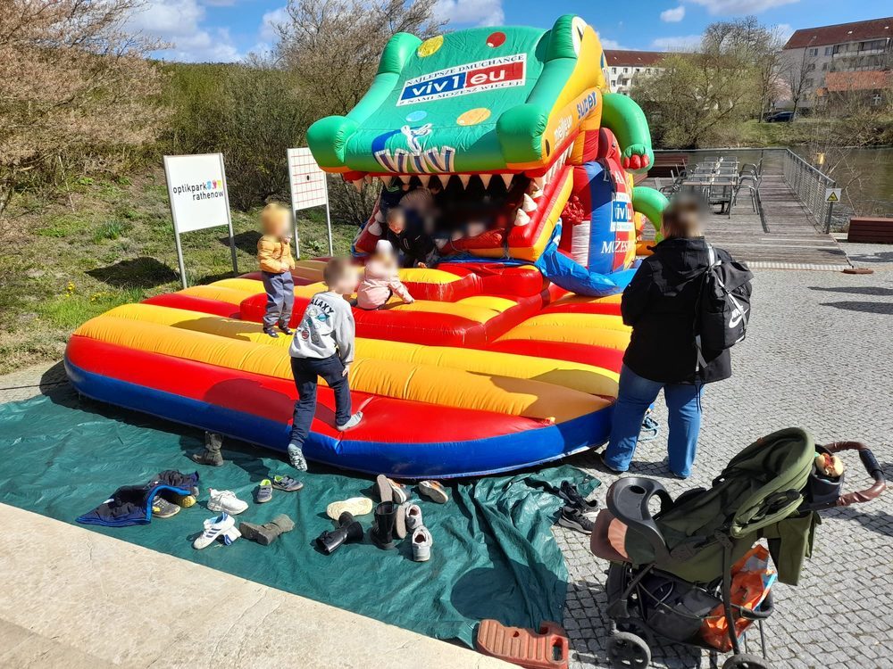 Hüpfburg in Form eines Krokodils mit Rutsche, Kinder spielen darin